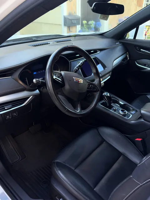 Clean black leather front seats and dashboard of a Cadillac XT4