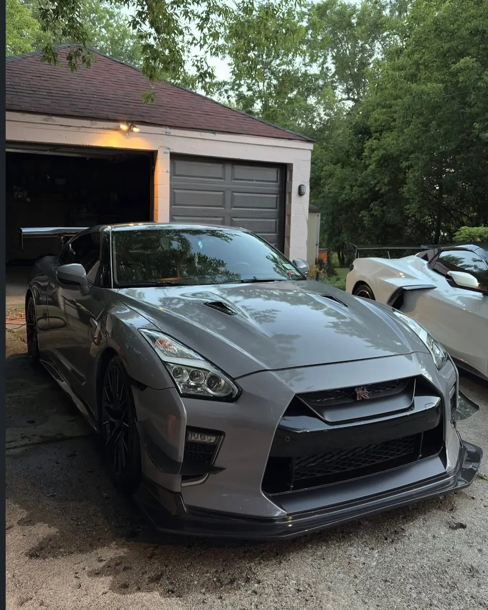 Gray Nissan GT-R parked in front of a garage, one of the client vehicles shared by Peak Auto Care