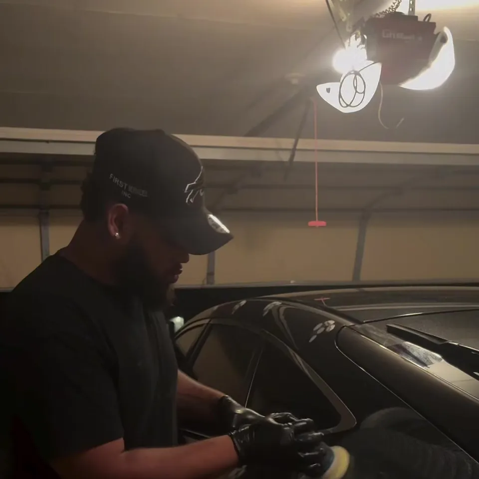 Peak Auto Care detailer machine polishing the paint of a black Honda Crosstour in a garage