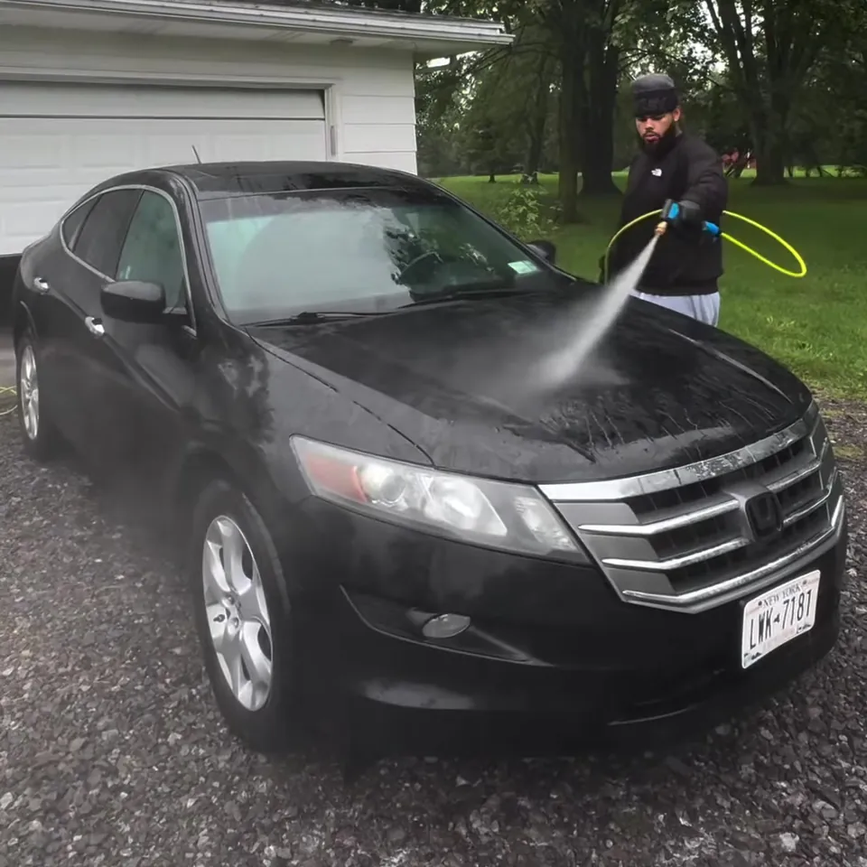 Detailer giving the Crosstour a full rinse with a pressure washer